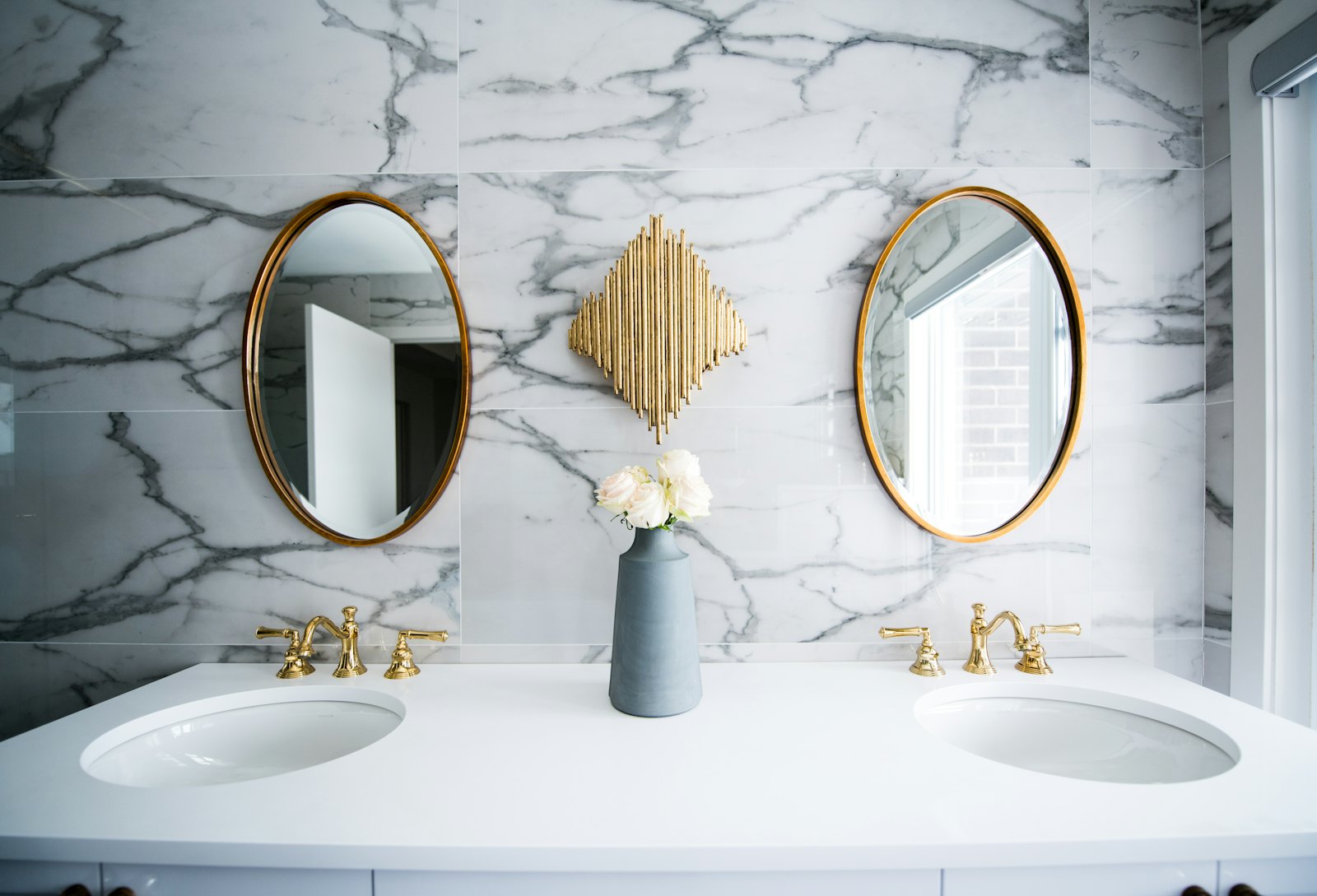 Calacatta Twin — Book-matched marble-effect porcelain, twin basins, brushed brass throughout.